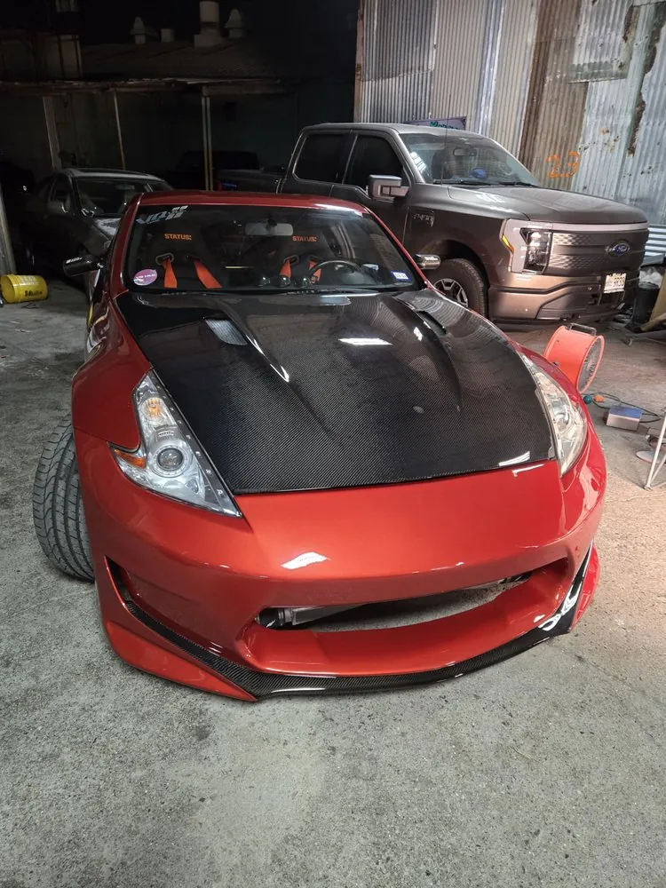 Red Nissan 370Z — Insurance work on the custom front bumper and the carbon-fiber hood, with carbon detailing added to the bumper.