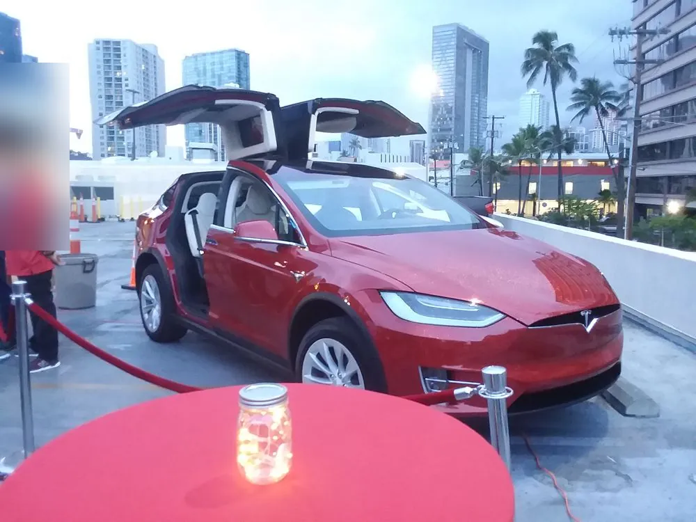 Red Tesla Model X — A custom flake paint job on a Model X, shown at an event.